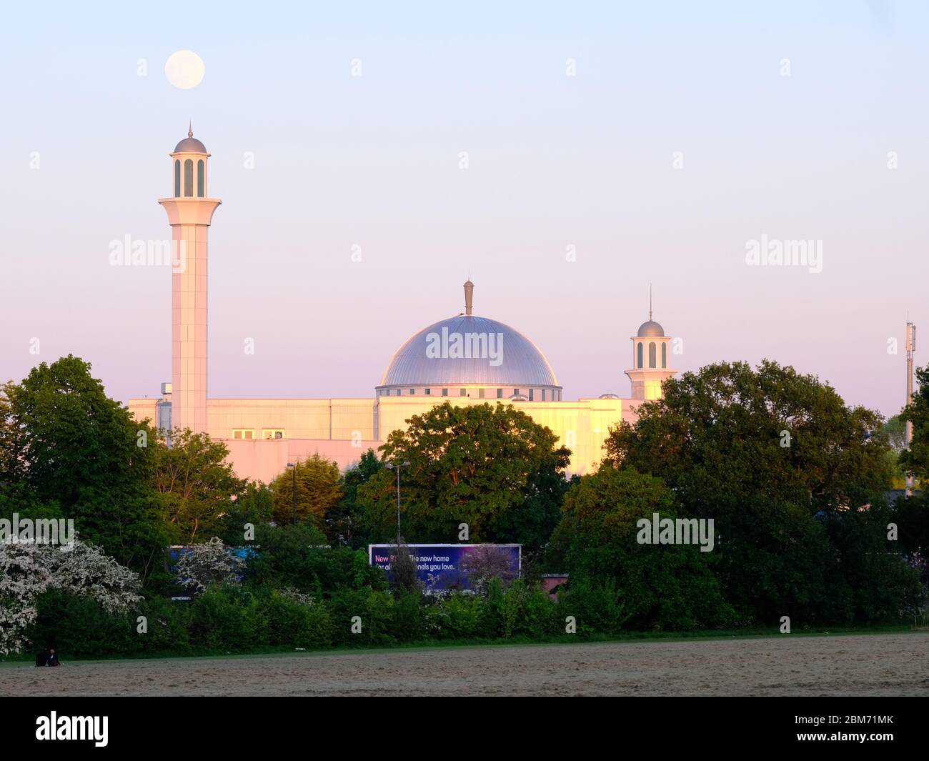 This year's final Supermoon rises on 6th May 2020 from behind the Baitul Futuh mosque in SW London. May's moon is known as the Flower moon. Stock Photo