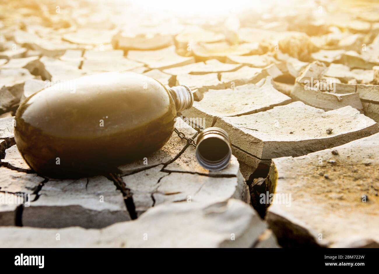 Empty flask in the desert. Drought and water scarcity caused by global warming Stock Photo