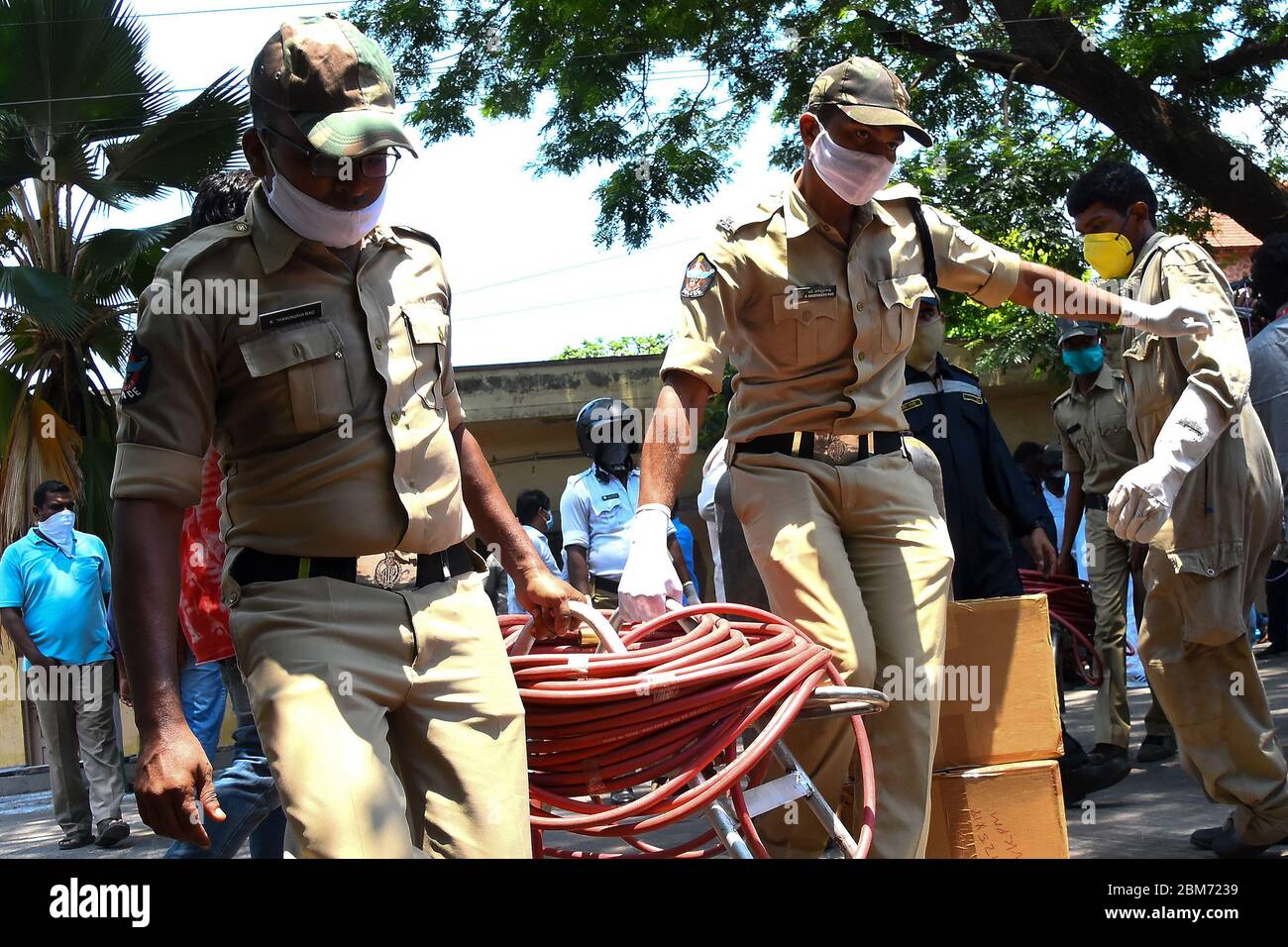 Andhra Pradesh, India. 7th May, 2020. Police personnel carry oxygen pipes after a gas leakage at the 'LG Polymers' chemical plant in the Vishakhapatnam district of Andhra Pradesh, India, May 7, 2020. The death toll in Thursday's gas leak incident in India's southern state Andhra Pradesh has risen to 11, confirmed Director General of the National Disaster Response Force (NDRF) S.N. Pradhan while addressing media persons in Delhi. Credit: Str/Xinhua/Alamy Live News Stock Photo