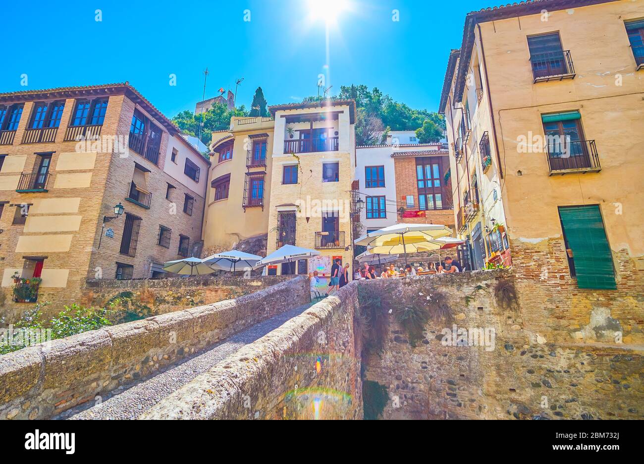 GRANADA, SPAIN - SEPTEMBER 25, 2019: The stone Puente Cabrera bridge leads to the old narrow streets at the foot of Sabika hill with old buildings, ca Stock Photo