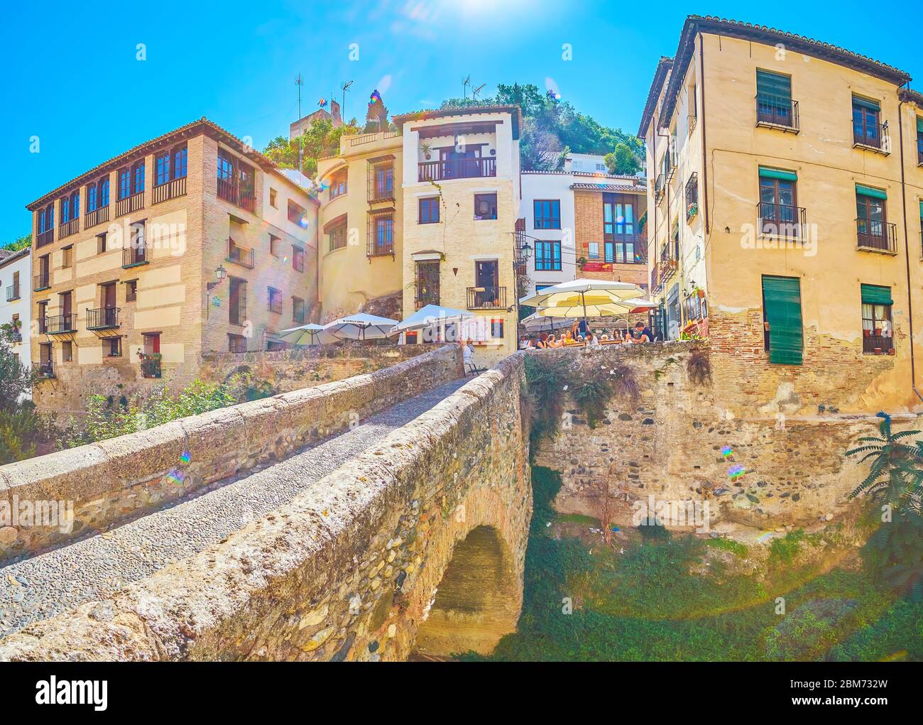 GRANADA, SPAIN - SEPTEMBER 25, 2019: Panorama of Cabrera bridge and foot of Sabika hill with old living buildings, cafes, bars, hotels and other touri Stock Photo