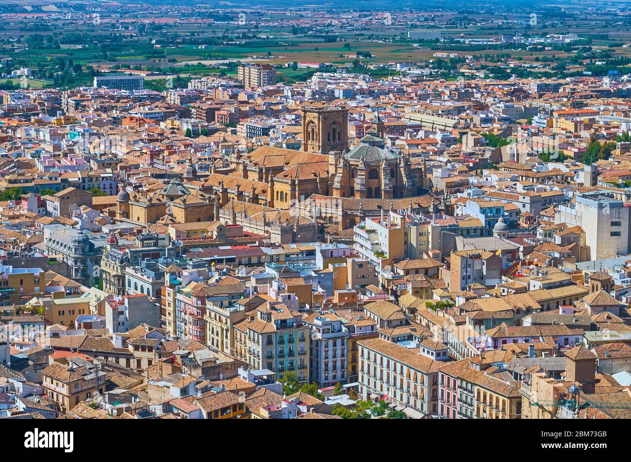 The tile city roof with rising apse and bell tower of Gothic Cathedral
