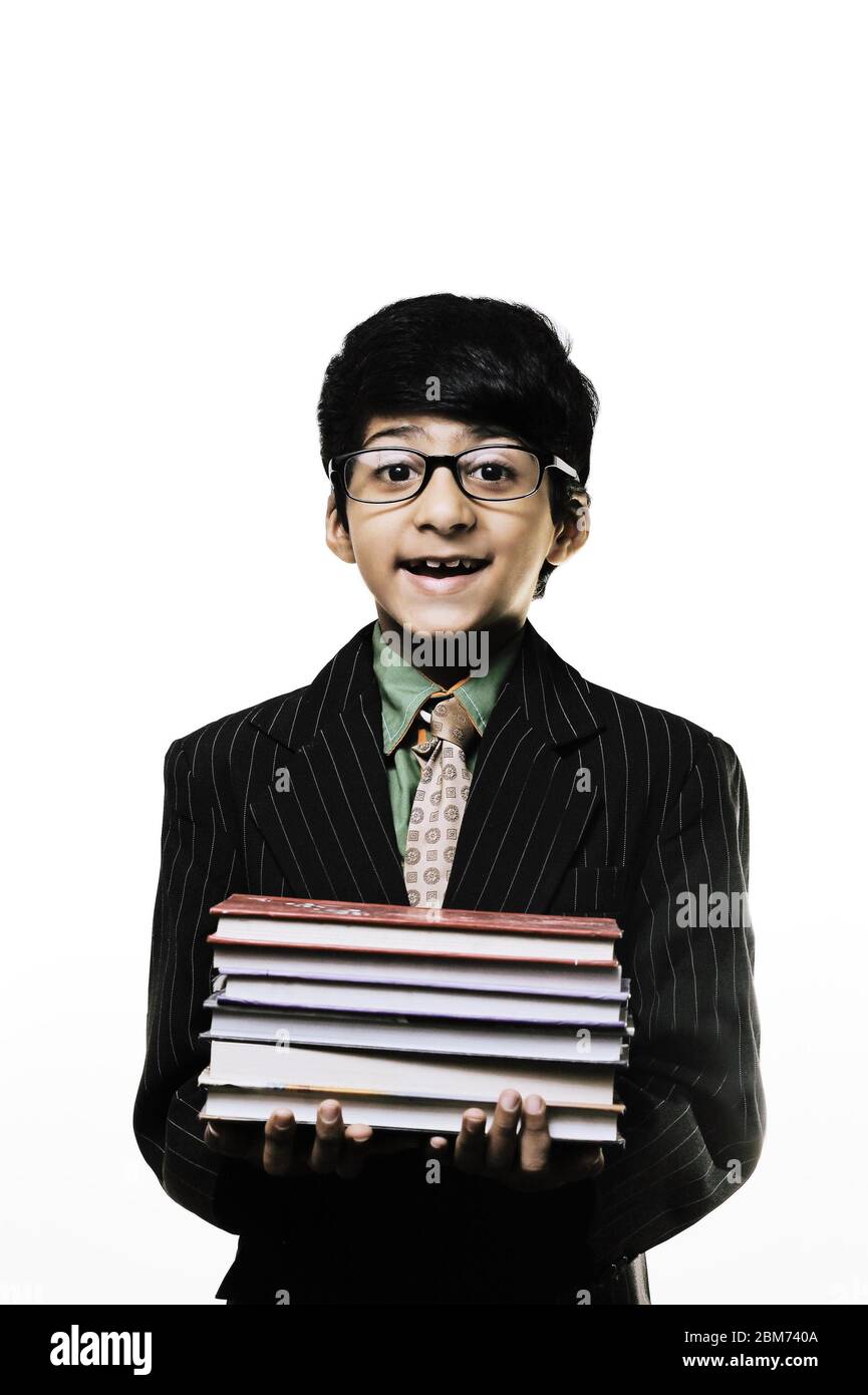 Cute Intelligent Little Boy Holding Books And Wearing Glasses, Smiling While isolated on white background Stock Photo