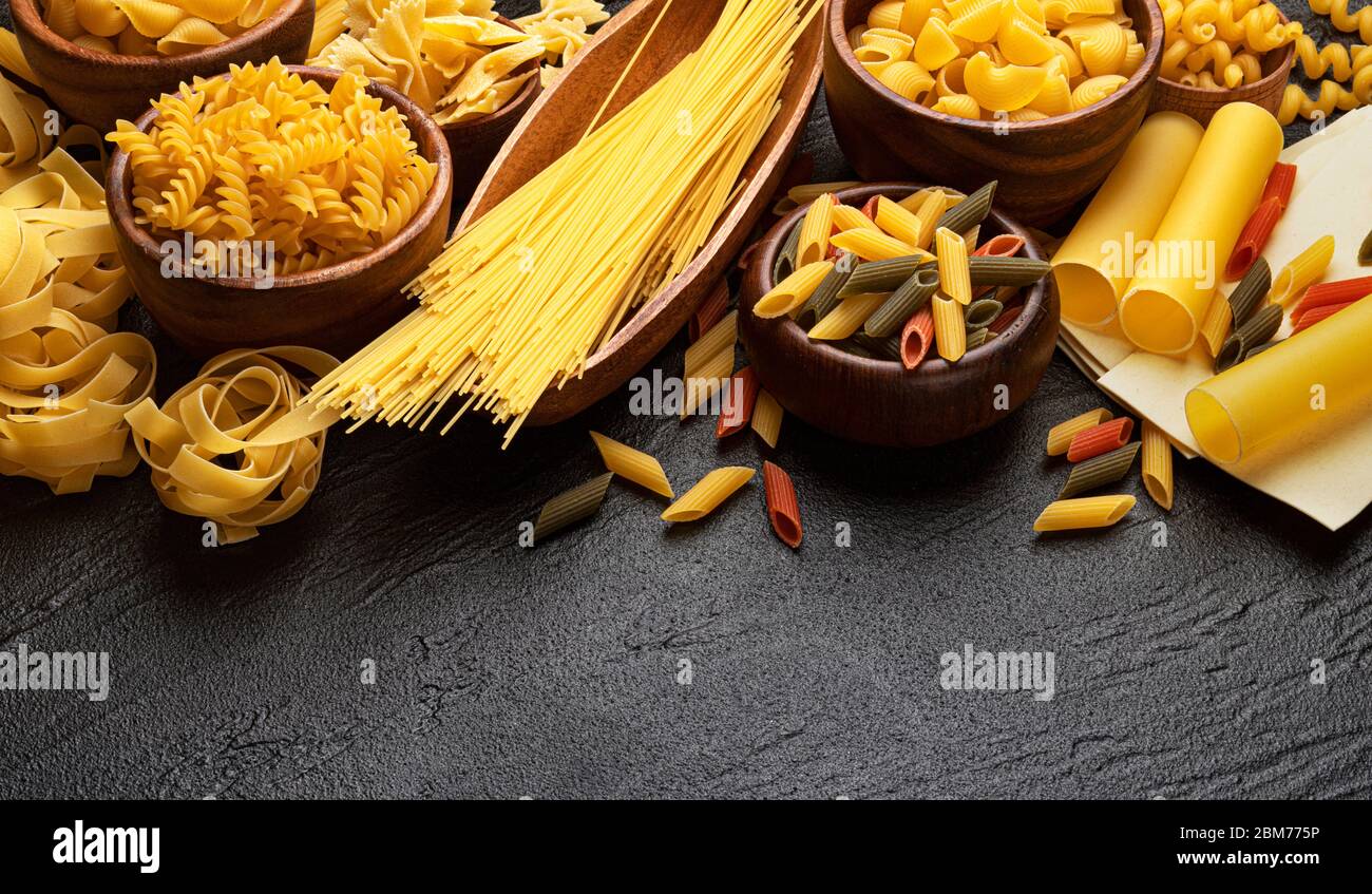 Different pasta types on black background with copy space for text ...