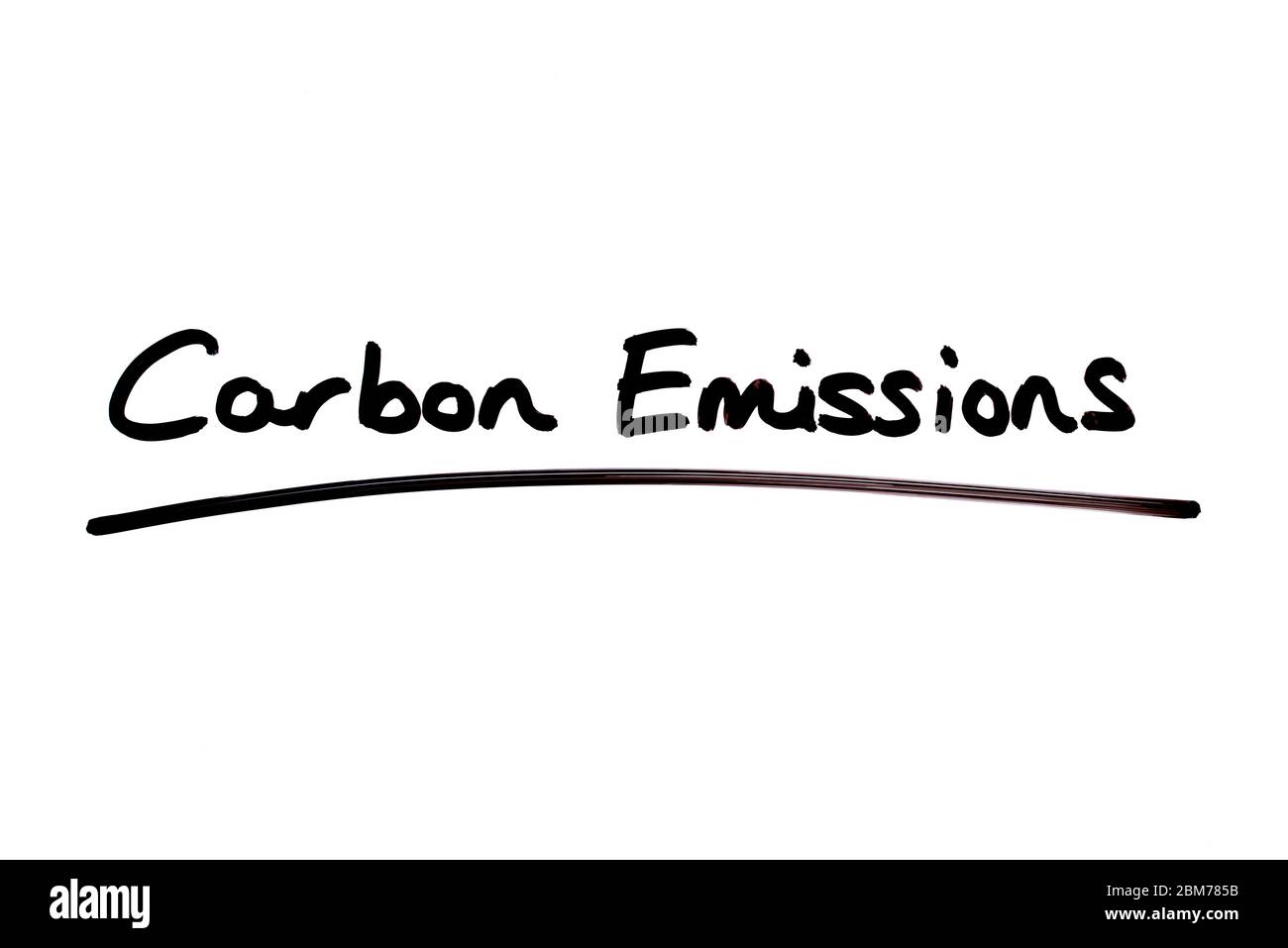 Carbon Emissions handwritten on a white background. Stock Photo
