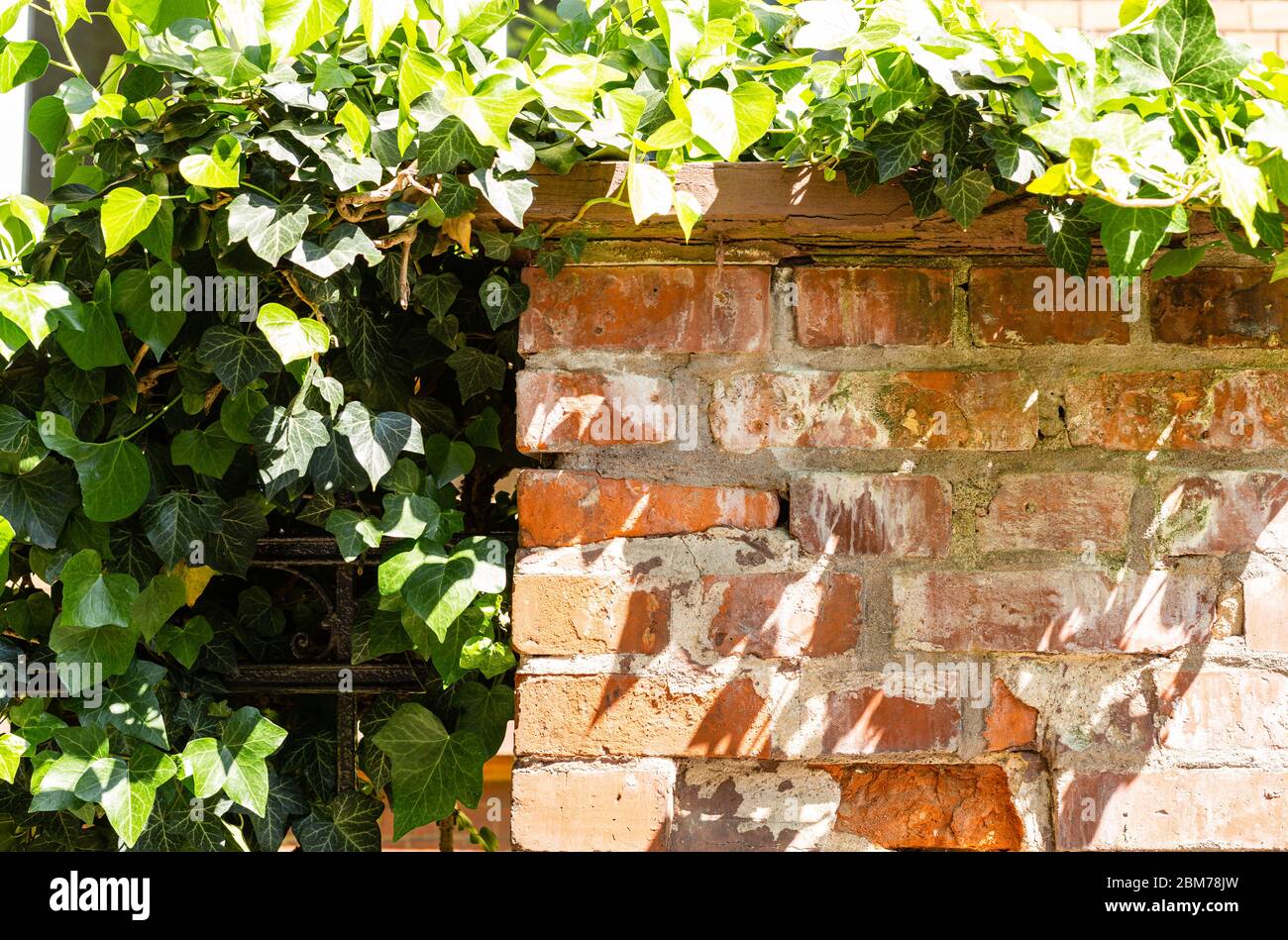 Fragments of a stone fence. Steel details of the fence. Bricks and plaster. Real estate fence. Stock Photo