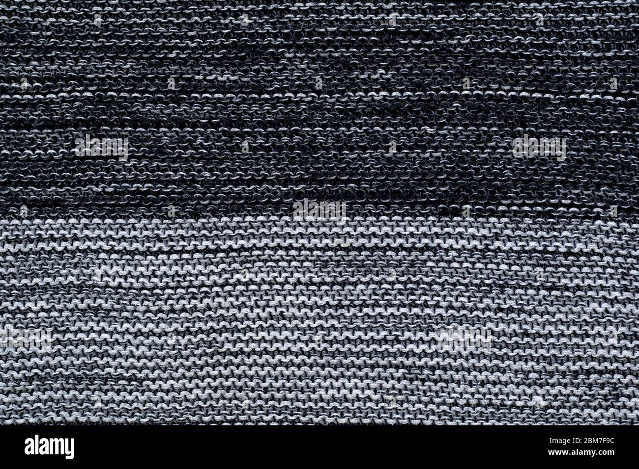 Black and white knitted texture, wallpaper. Abstract knitwear background. Gray jersey Stock Photo