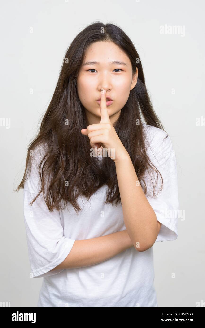 Portrait of young beautiful Asian woman with finger on lips Stock Photo ...