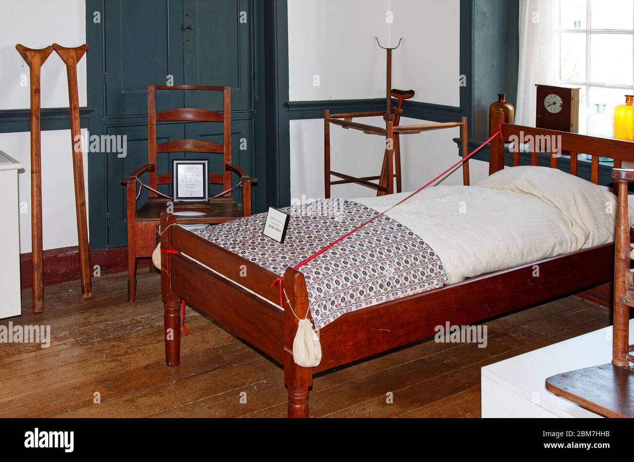 Shaker resident's bedroom, plain wood furniture, single bed, commode, crutches, walker, antiques, sick room, unadorned walls, Shaker Village of Pleasa Stock Photo