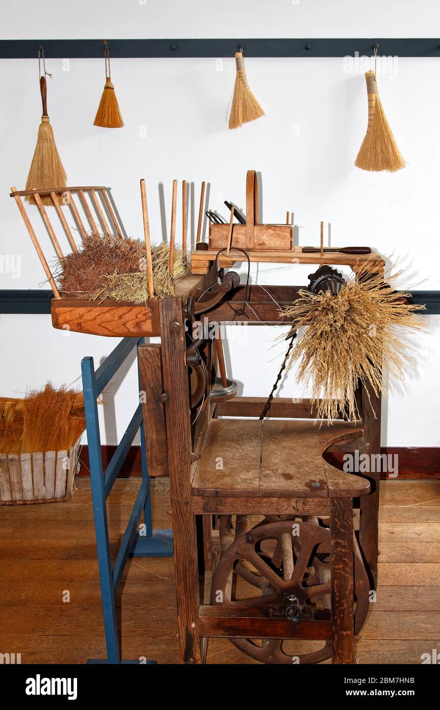 broom making machine, wood, antique, straw, small brooms on wall, Shaker Village of Pleasant Hill, defunct religious community; Kentucky; USA, Harrods Stock Photo