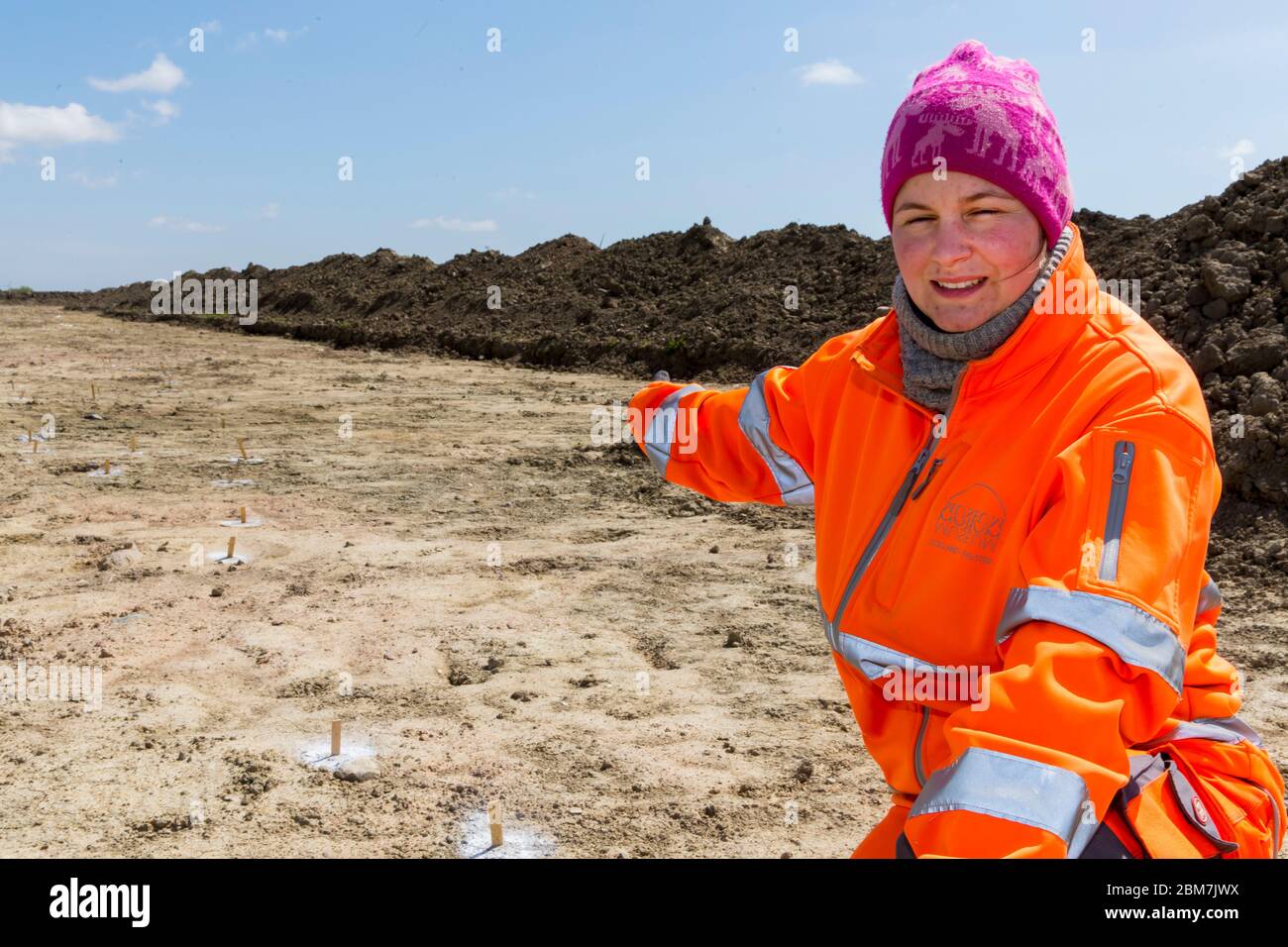 RODBY, DENMARK - MAY 06, 2020: An enthusiastic archaeologist from Museum Lolland-Falster in Denmark, Jannice Kristiansen, at the 1 km long and 15 meter wide excavation pit which have revealed a 2.000 years old Iron Age defence belt at the soon to come Fehmernbelt Tunnel construction site in the south-eastern Denmark at the Baltic Sea shoreline. The defence line consist of some 5.000 holes, probably with hidden sharp oak spikes so an invading force coming from the sea, maybe from Northern Germany, would be injured by spikes penetrating their feet, or horses would plunge to the ground. The e Stock Photo