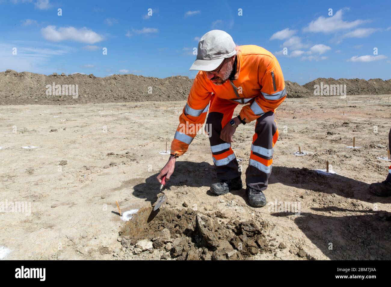 RODBY, DENMARK - MAY 06, 2020:  Archaeologist from Museum Lolland-Falster in Denmark, Søren Jensen, at  work with his brick trowel at the  1 km long and 15 meter wide excavation pit which have revealed a 2.000 years old Iron Age defence belt at the soon to come Fehmernbelt Tunnel  construction site in the south-eastern  Denmark at the Baltic Sea shoreline. The defence line consist of some 5.000 holes, probably with hidden sharp oak spikes so an invading force coming from the sea, maybe from Northern Germany, would be injured by spikes penetrating their feet, or horses would plunge to the groun Stock Photo