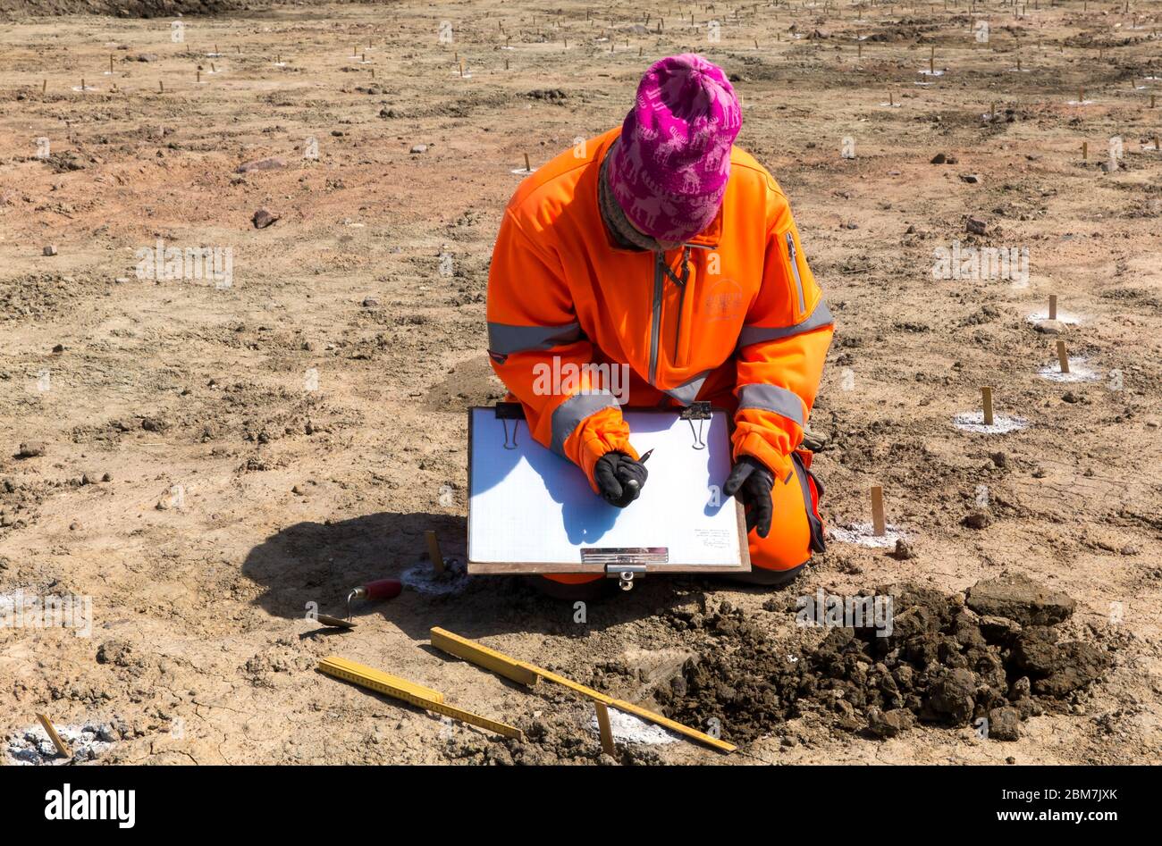 RODBY, DENMARK - MAY 06, 2020: Archaeologist from Museum Lolland-Falster in Denmark, Jannice Kristiansen, at work at the 1 km long and 15 meter wide excavation pit which have revealed a 2.000 years old Iron Age defence belt at the soon to come Fehmernbelt Tunnel construction site in the south-eastern Denmark at the Baltic Sea shoreline. The defence line consist of some 5.000 holes, probably with hidden sharp oak spikes so an invading force coming from the sea, maybe from Northern Germany, would be injured by spikes penetrating their feet, or horses would plunge to the ground. The excavat Stock Photo