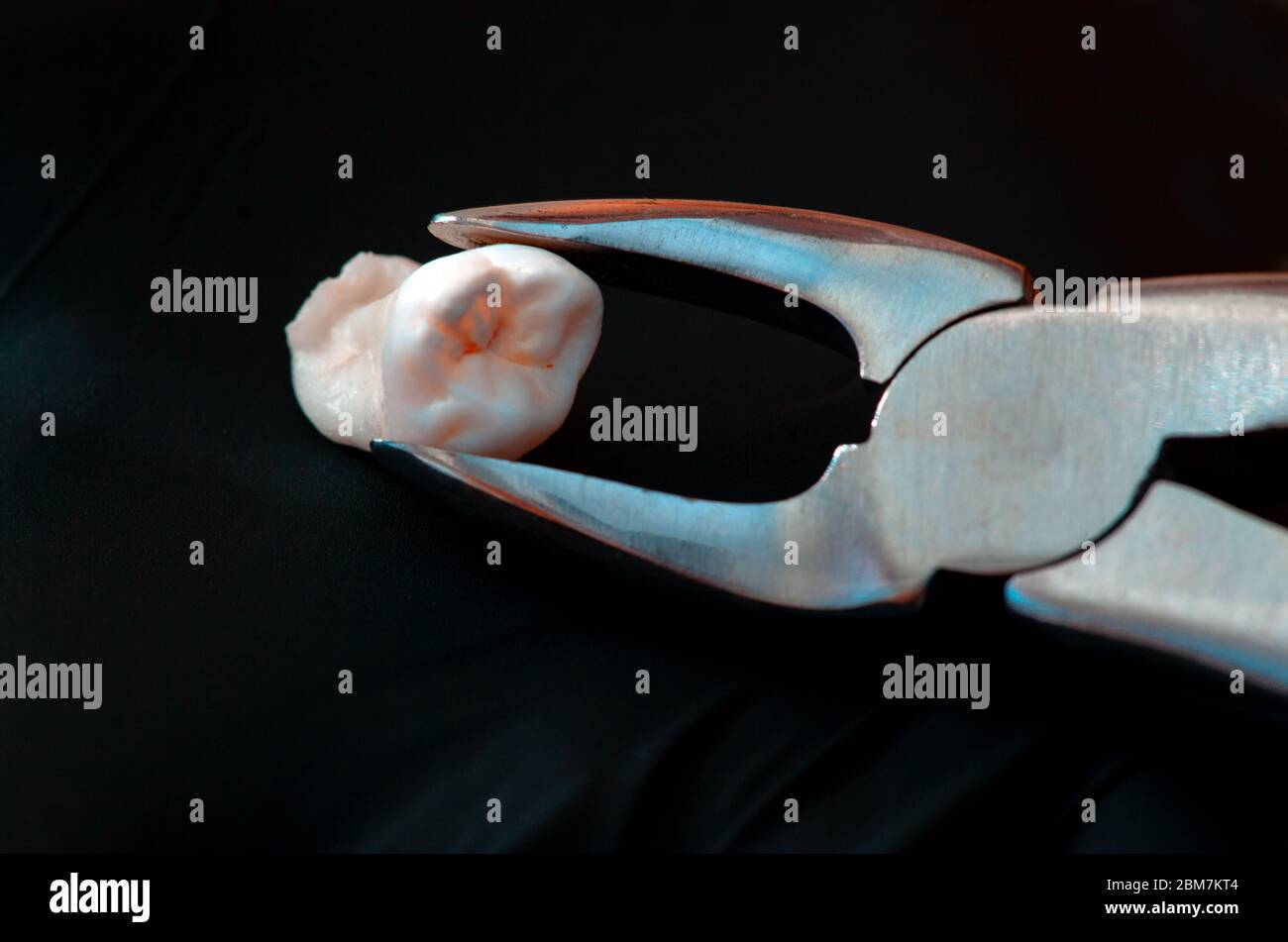 Dental tools and remove tooth at clinic isolated on black. Wisdom tooth