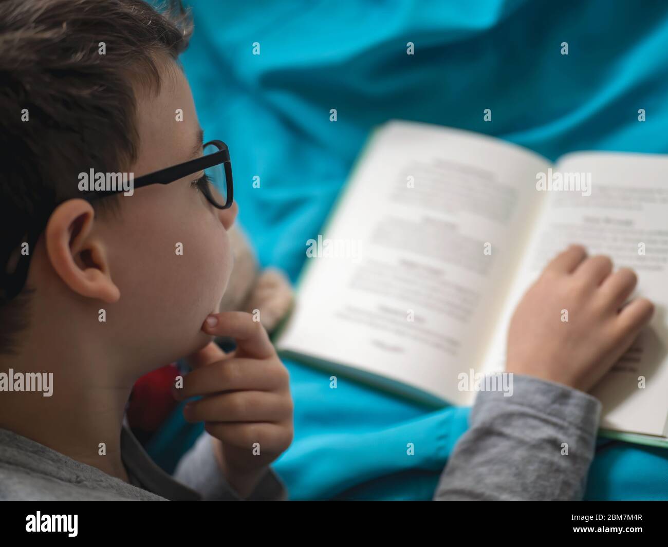 Little child, 8 years old boy reading a book at home Stock Photo