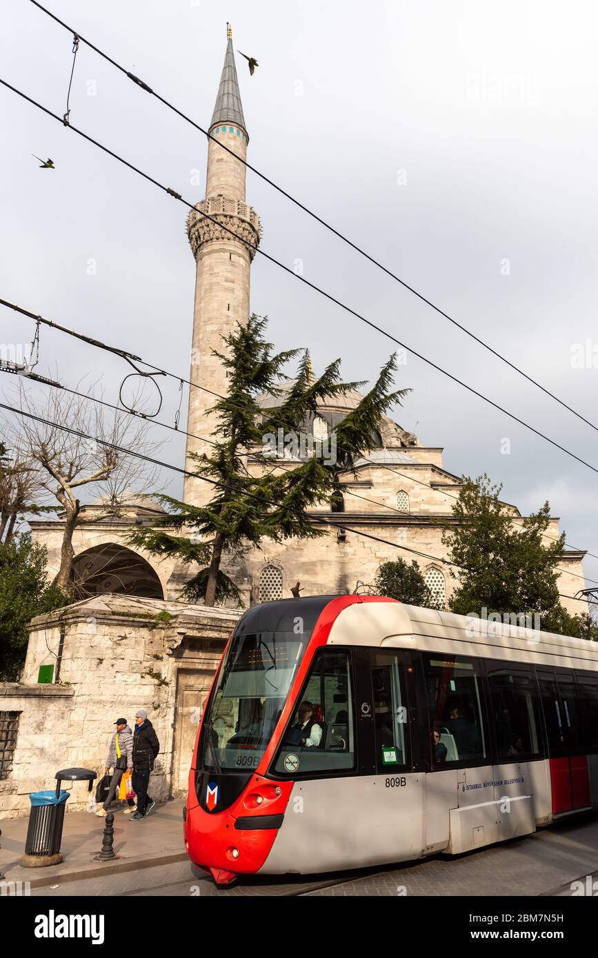 February 21, 2018: Tram passing near a mosque in Sultanhamet district. Istanbul, Turkey Stock Photo