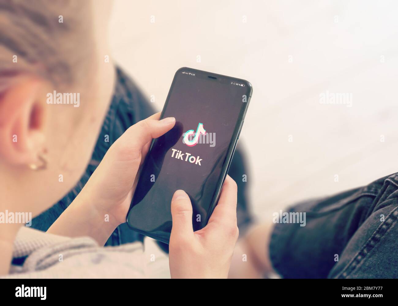 KYIV, UKRAINE-JANUARY, 2020: Tiktok on Smart Phone Screen. Young Girl Pointing or Texting Tiktok on Smart Phone During a Pandemic Self-Isolation and Coronavirus Prevention. Stock Photo