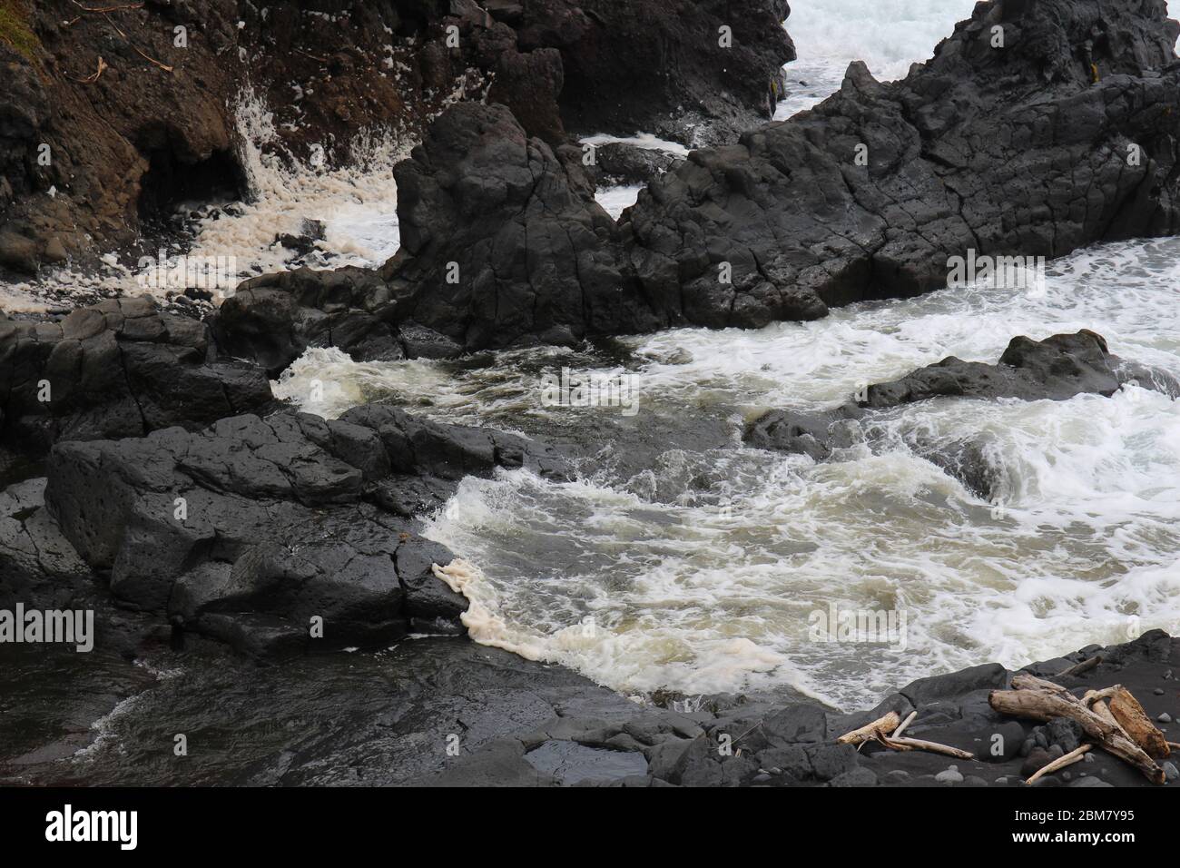 Palikea stream running through volcanic rock and flowing into the Pacific Ocean at the Oheo Gulch in Hana, Maui, Hawaii, USA Stock Photo