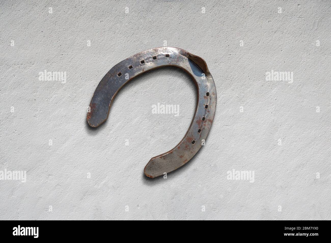 meatl horseshoe for luck and wellness on a cemete surface Stock Photo
