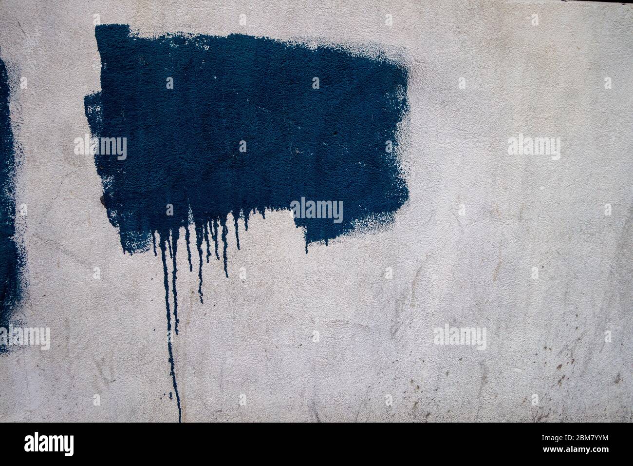 textured painted area on white wall with driipping bottom background; backdrop Stock Photo