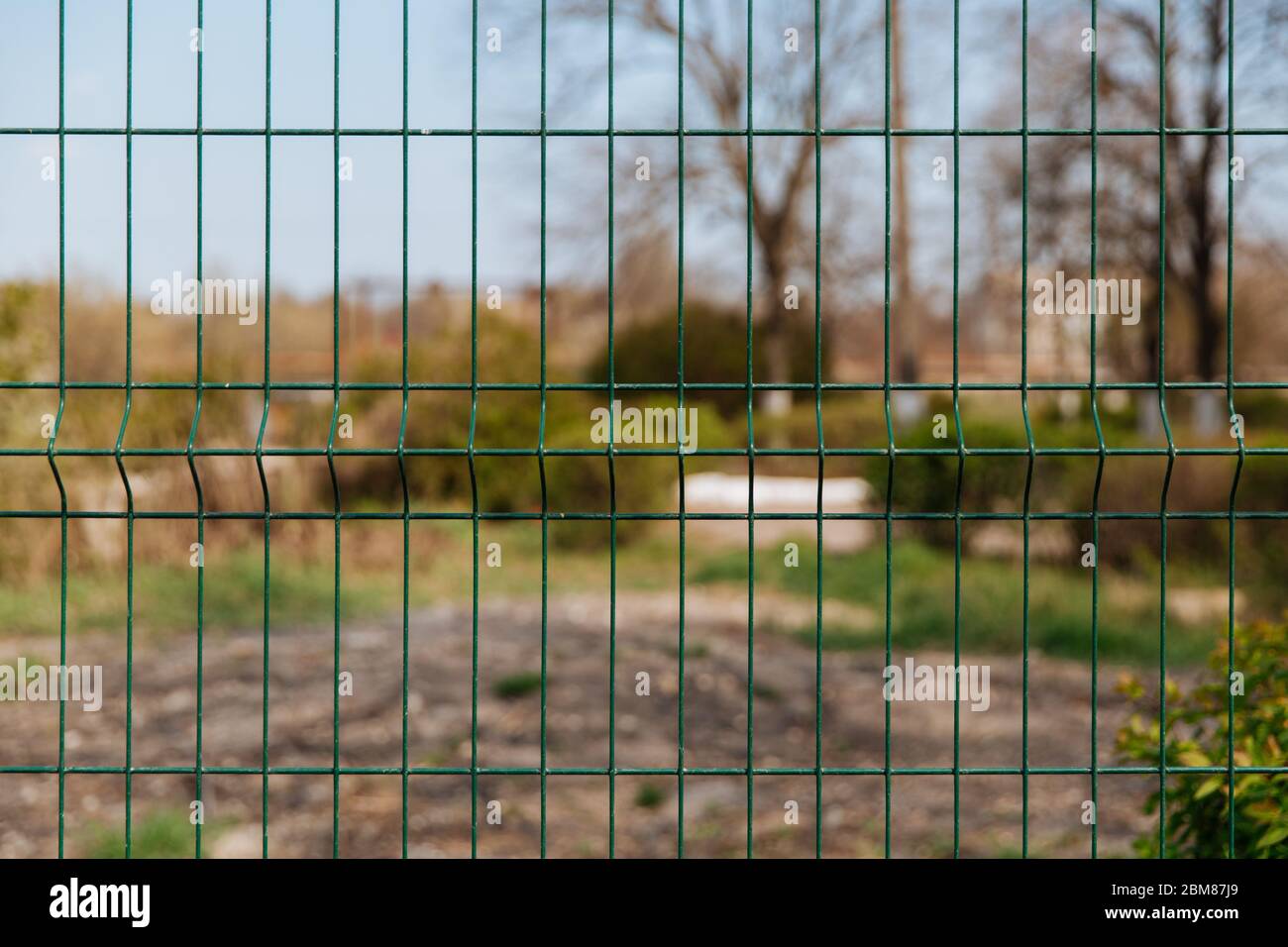 Steel grill fence with blurred wire background Stock Photo - Alamy