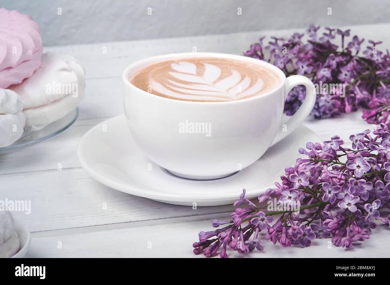 https://c8.alamy.com/comp/2BM8AYJ/lilac-coffee-cup-with-latte-art-and-white-and-pink-marshmallow-on-white-wooden-table-romantic-morning-flat-lay-2BM8AYJ.jpg