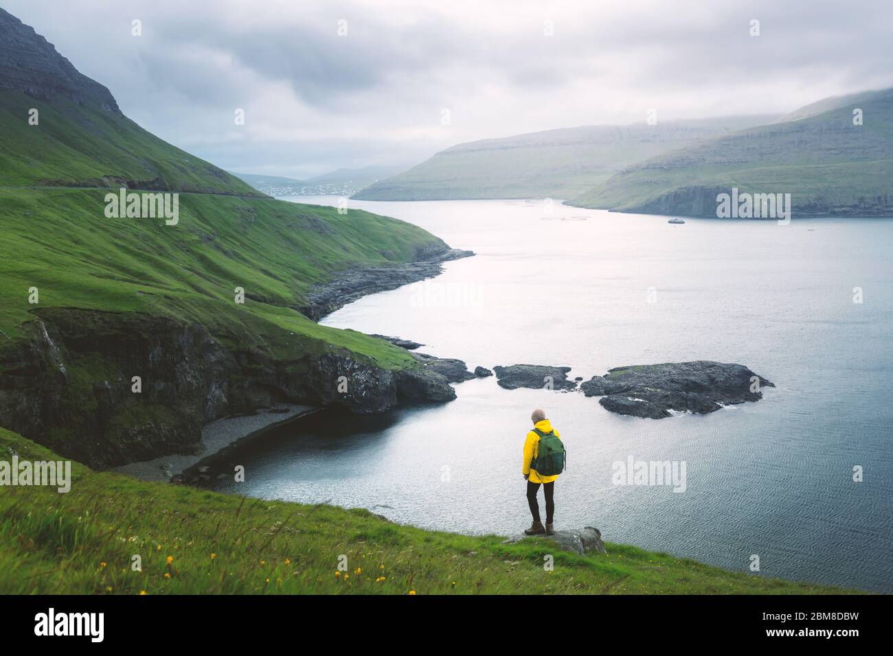 Dramatic view of green hills of Vagar island and Sorvagur town on background. Faroe islands, Denmark. Landscape photography Stock Photo