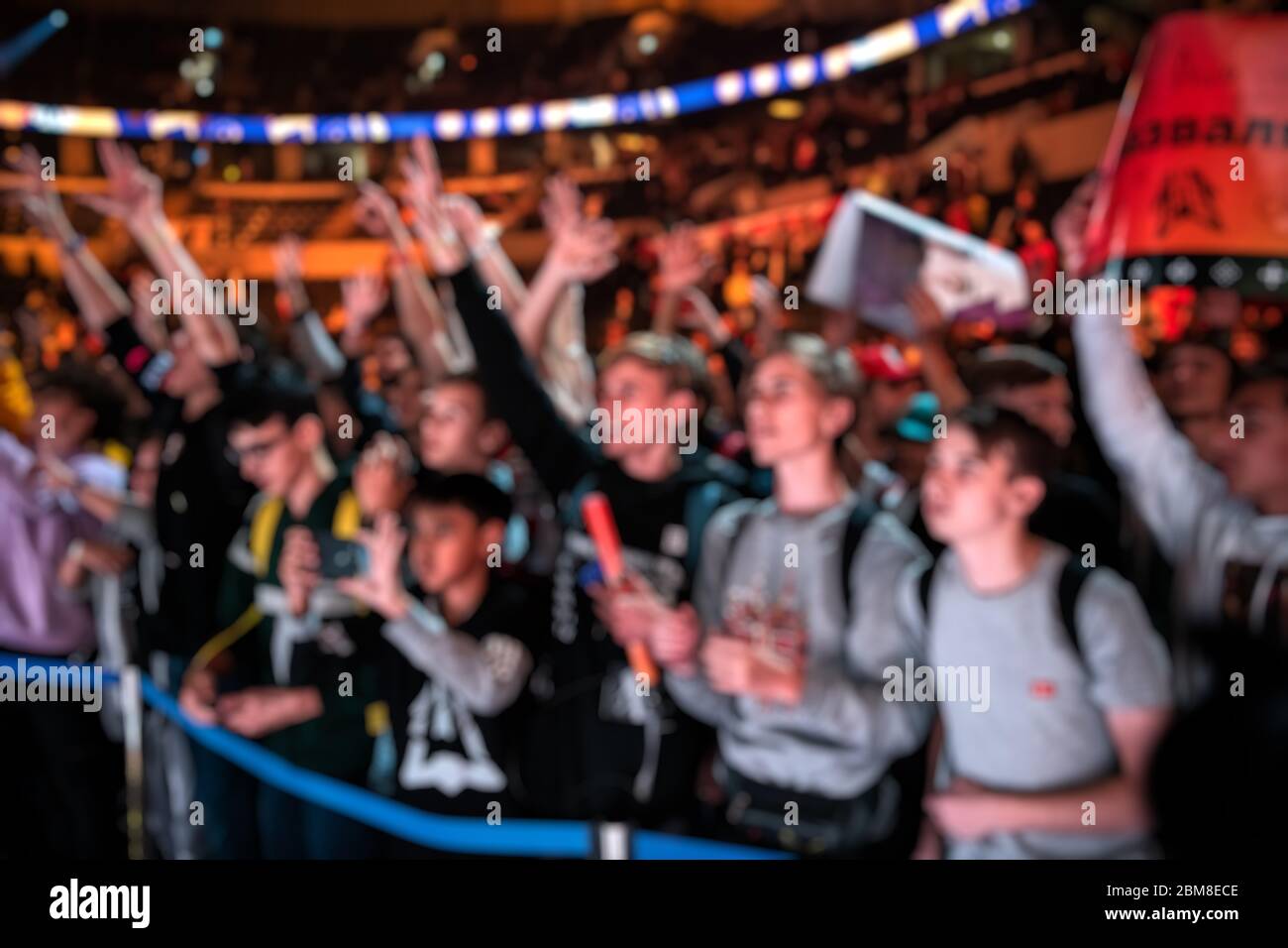 Blurred background of an esports event - A lot of fans on a tribune at  tournament's arena with hands raised. Cheering for their favorite team  Stock Photo - Alamy