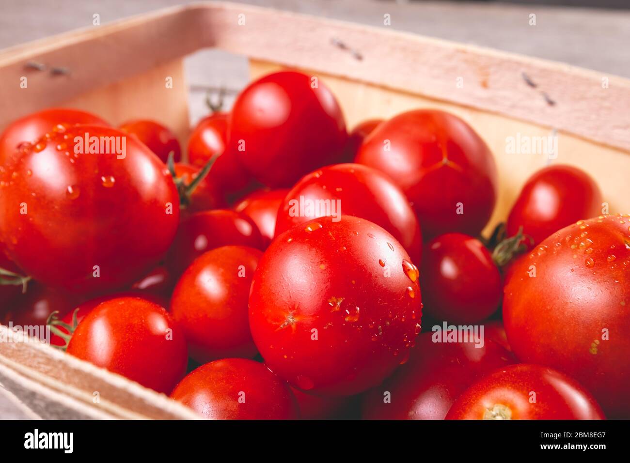 ripe tomatoes in a small wooden crate in studio Stock Photo - Alamy