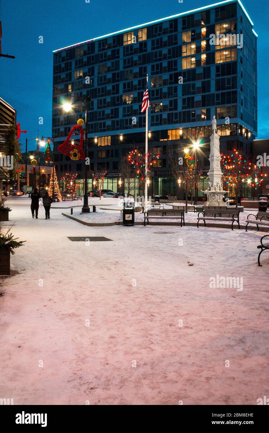 people walking through a city park during Christmas time in Grand 