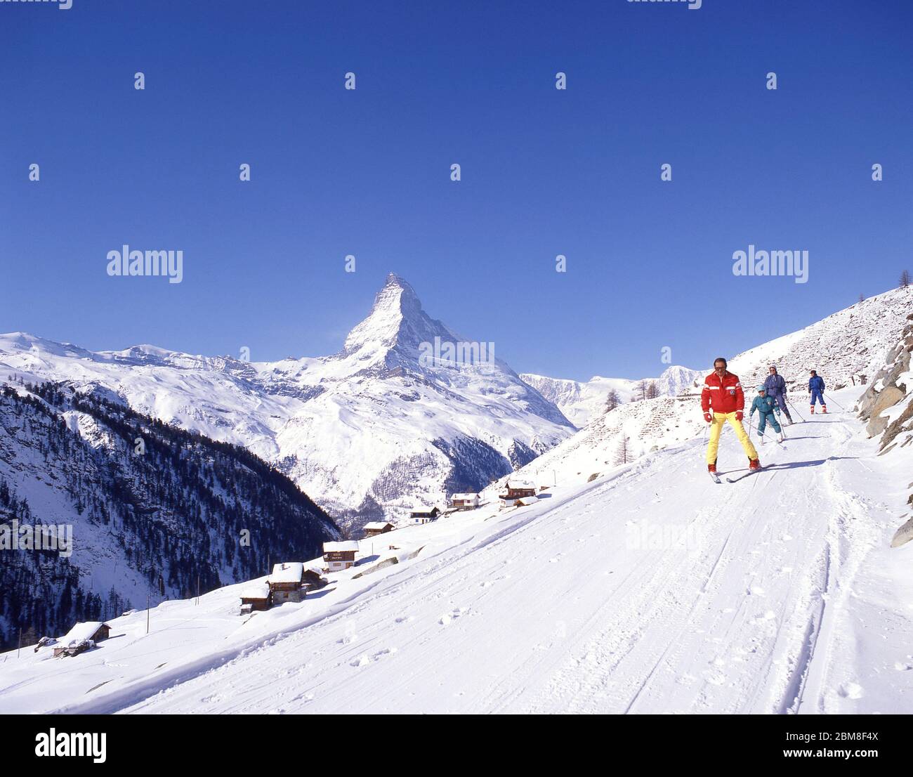 Skiers on track with Matterhorn Mountain behind, Zermatt, The Valais, Switzerland Stock Photo