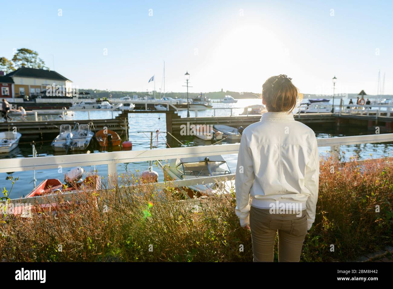 Rear view of young Asian woman looking at beautiful view of the pier outdoors Stock Photo