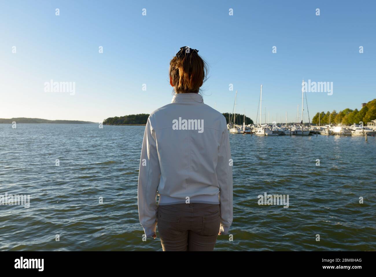 Rear view of young Asian woman looking at view of the sea Stock Photo