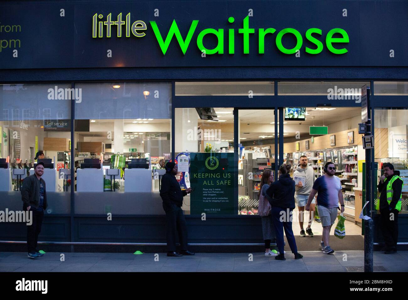 London, UK, 7 May 2020: on Clapham High Street, at a branch of Waitrose, customers wait outside but social distancing rules are not strictly met as shoppers leave and enter the store. Anna Watson/Alamy Live News Stock Photo