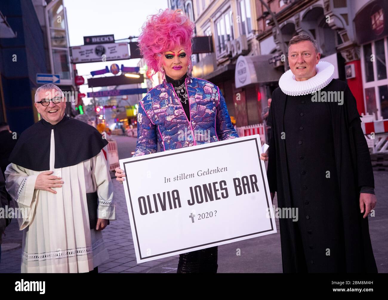 07 May 2020, Hamburg: Olivia Jones (M), drag queen and entrepreneur, Sieghard Wilm (r), pastor of the St. Pauli Church, and Karl Schultz, pastor at the St. Joseph Church, stand in front of the Große Freiheit on the Reeperbahn during a protest action of neighborhood restaurateurs, club and pub owners on Beatles Platz. In the Hamburg cult district of St. Pauli, bar and pub owners drew attention to their existential needs on Thursday evening because of the Corona crisis and demanded more financial aid. The initiator of the protest action on the Reeperbahn was drag queen Olivia Jones, who runs sev Stock Photo