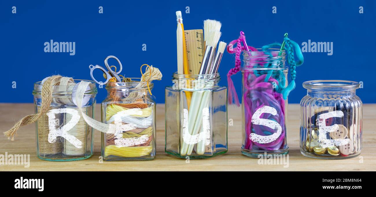 Recycled jars reused for storing crafting materials with reuse text, recycling at home for sustainable living, save money and zero waste Stock Photo