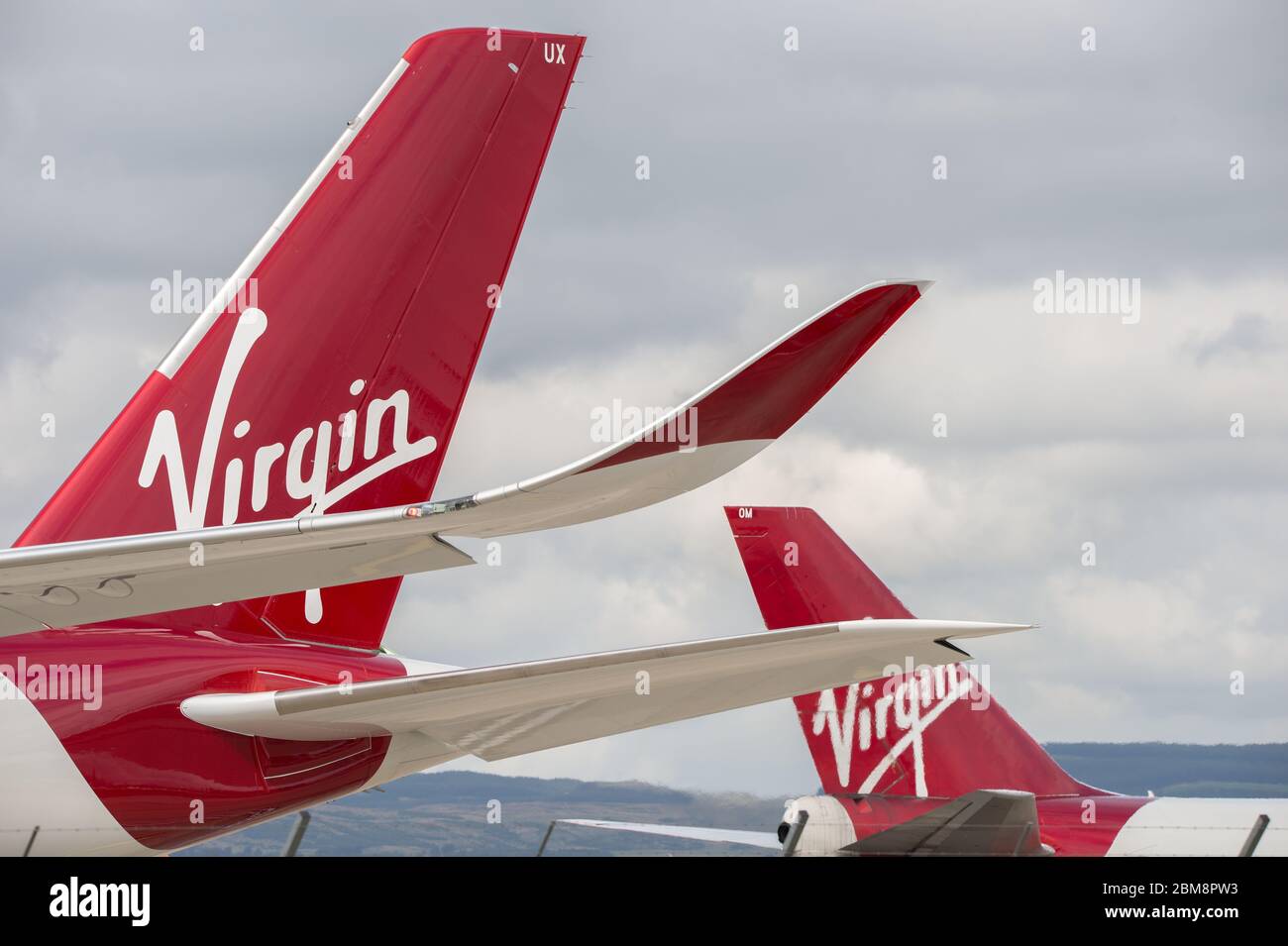 Glasgow, UK. 25 August 2019.  Pictured: (foreground) Virgin Atlantic's brand new flagship long haul aircraft, Airbus A350-1000 (reg G-VLUX) nicknamed Red Velvet which has the altar curved slender looking wingtips; (background), Virgin Atlantic Boeing 747-400 reg G-VROM nicknamed Barbarella is one of the long haul wide die body aircraft in Virgin's leisure fleet. Normally covering London Gatwick, this aircraft serves Glasgow 3 times per week. Credit: Colin Fisher/Alamy Live News. Stock Photo