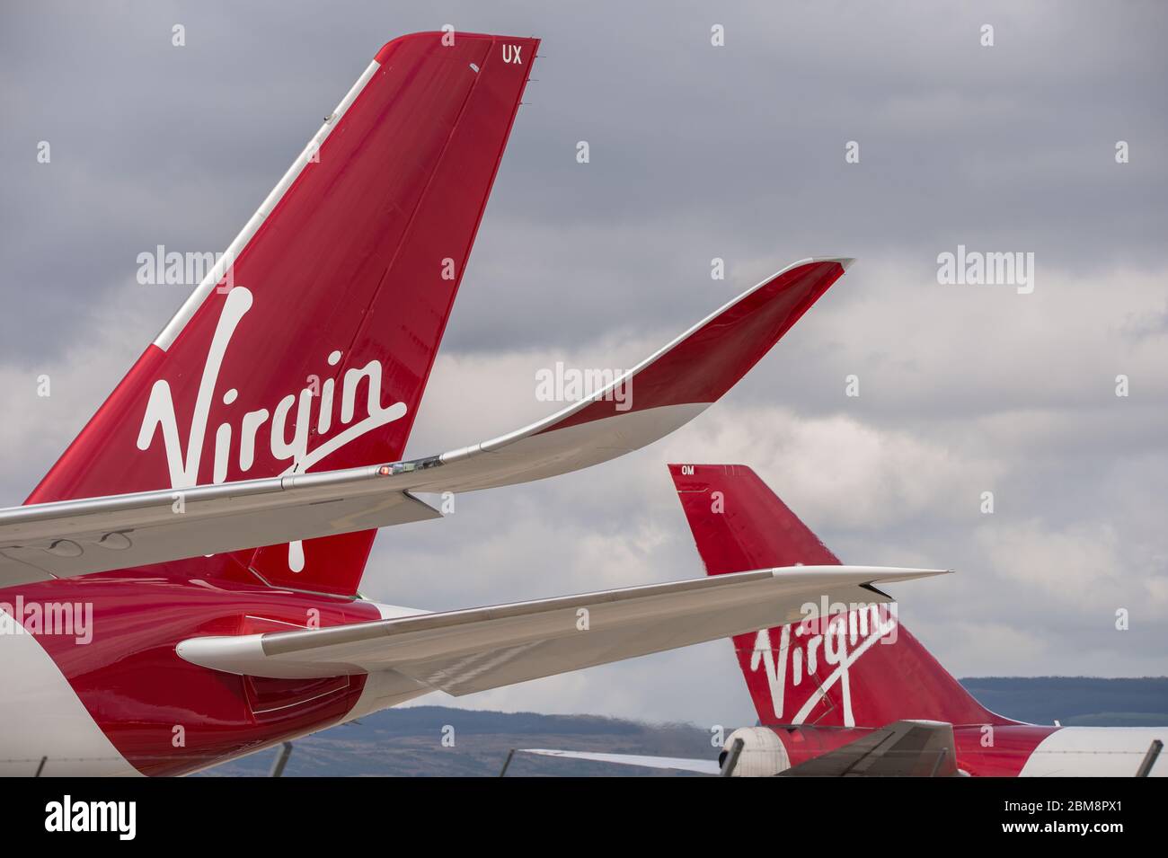 Glasgow, UK. 25 August 2019. Pictured: (foreground) Virgin Atlantic's brand new flagship long haul aircraft, Airbus A350-1000 (reg G-VLUX) nicknamed Red Velvet which has the altar curved slender looking wingtips; (background), Virgin Atlantic Boeing 747-400 reg G-VROM nicknamed Barbarella is one of the long haul wide die body aircraft in Virgin's leisure fleet. Normally covering London Gatwick, this aircraft serves Glasgow 3 times per week. Credit: Colin Fisher/Alamy Live News. Stock Photo