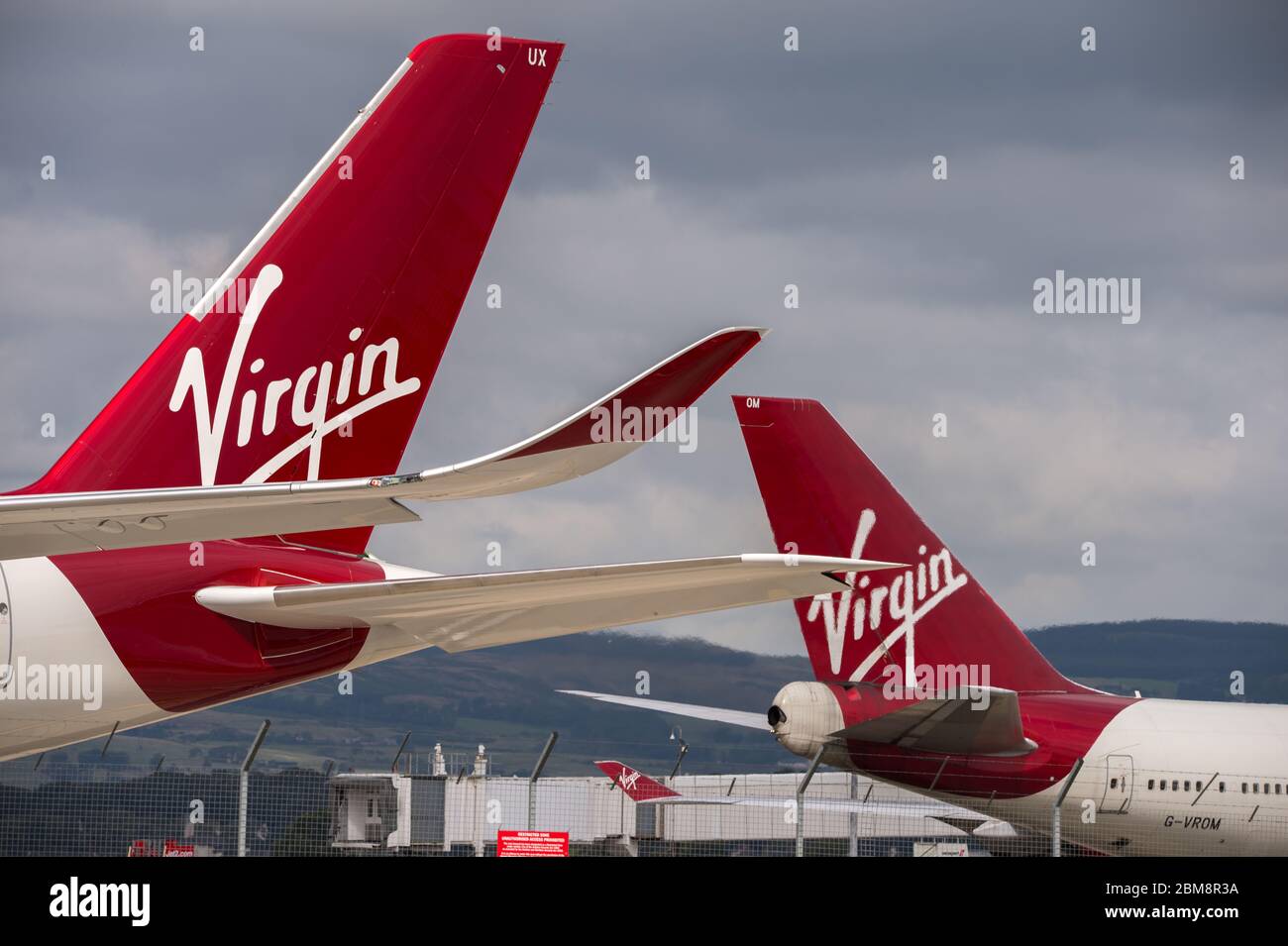 Glasgow, UK. 25 August 2019.  Pictured: (foreground) Virgin Atlantic's brand new flagship long haul aircraft, Airbus A350-1000 (reg G-VLUX) nicknamed Red Velvet which has the altar curved slender looking wingtips; (background), Virgin Atlantic Boeing 747-400 reg G-VROM nicknamed Barbarella is one of the long haul wide die body aircraft in Virgin's leisure fleet. Normally covering London Gatwick, this aircraft serves Glasgow 3 times per week. Credit: Colin Fisher/Alamy Live News. Stock Photo