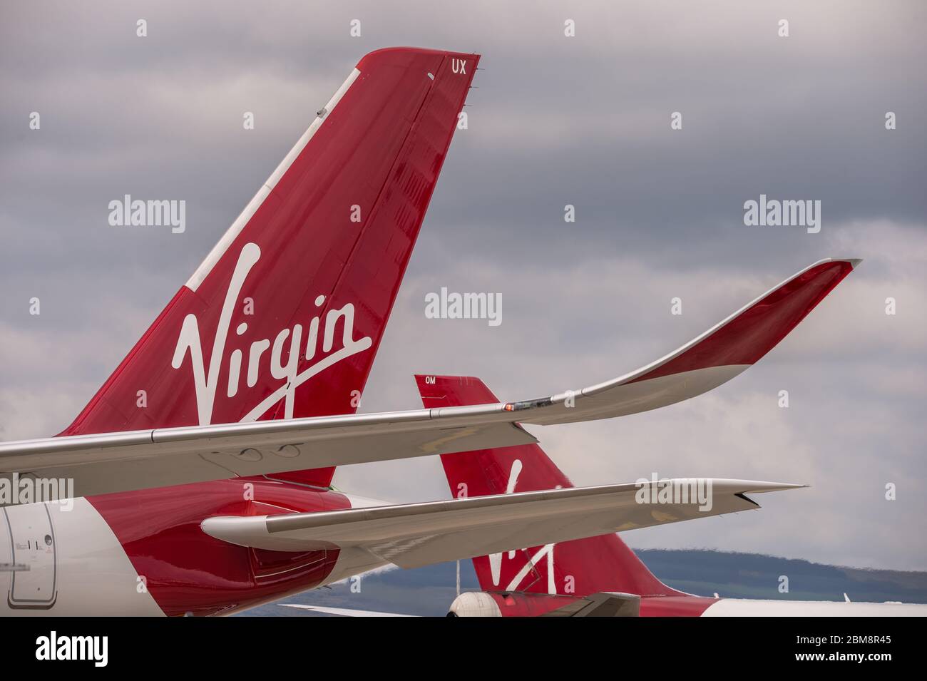 Glasgow, UK. 25 August 2019.  Pictured: (foreground) Virgin Atlantic's brand new flagship long haul aircraft, Airbus A350-1000 (reg G-VLUX) nicknamed Red Velvet which has the altar curved slender looking wingtips; (background), Virgin Atlantic Boeing 747-400 reg G-VROM nicknamed Barbarella is one of the long haul wide die body aircraft in Virgin's leisure fleet. Normally covering London Gatwick, this aircraft serves Glasgow 3 times per week. Credit: Colin Fisher/Alamy Live News. Stock Photo