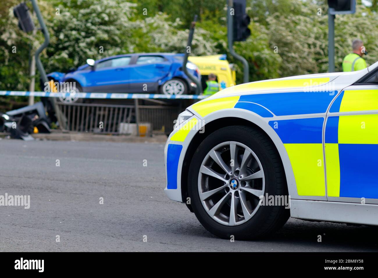 A car is left on it's side, after colliding with traffic lights at a