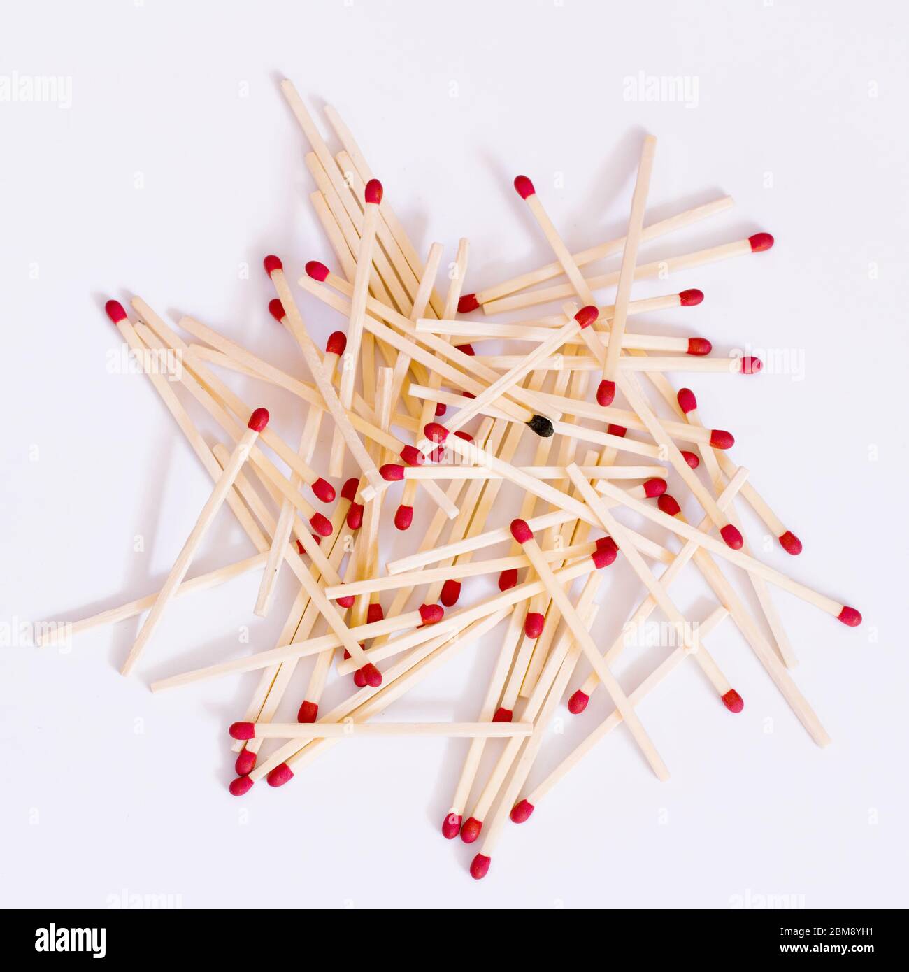 A single burnt match in a pile of matches Stock Photo