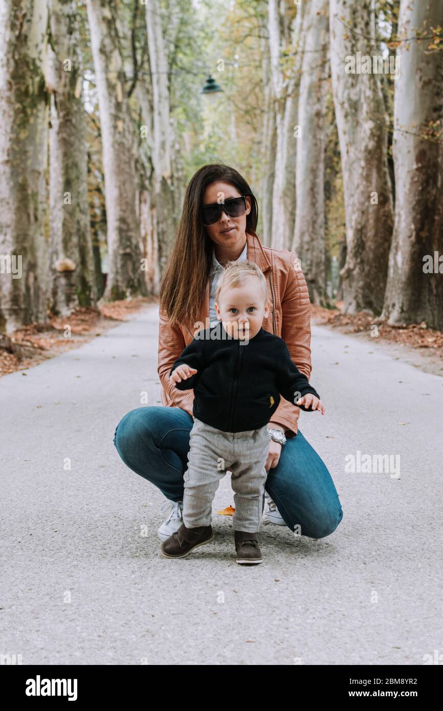Young beautiful woman and her 1 year old son outdoors, family love Stock Photo