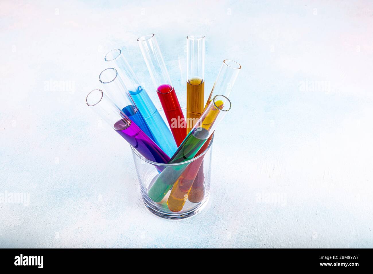 Test tubes in a rack containing rainbow colored solutions. Laboratory