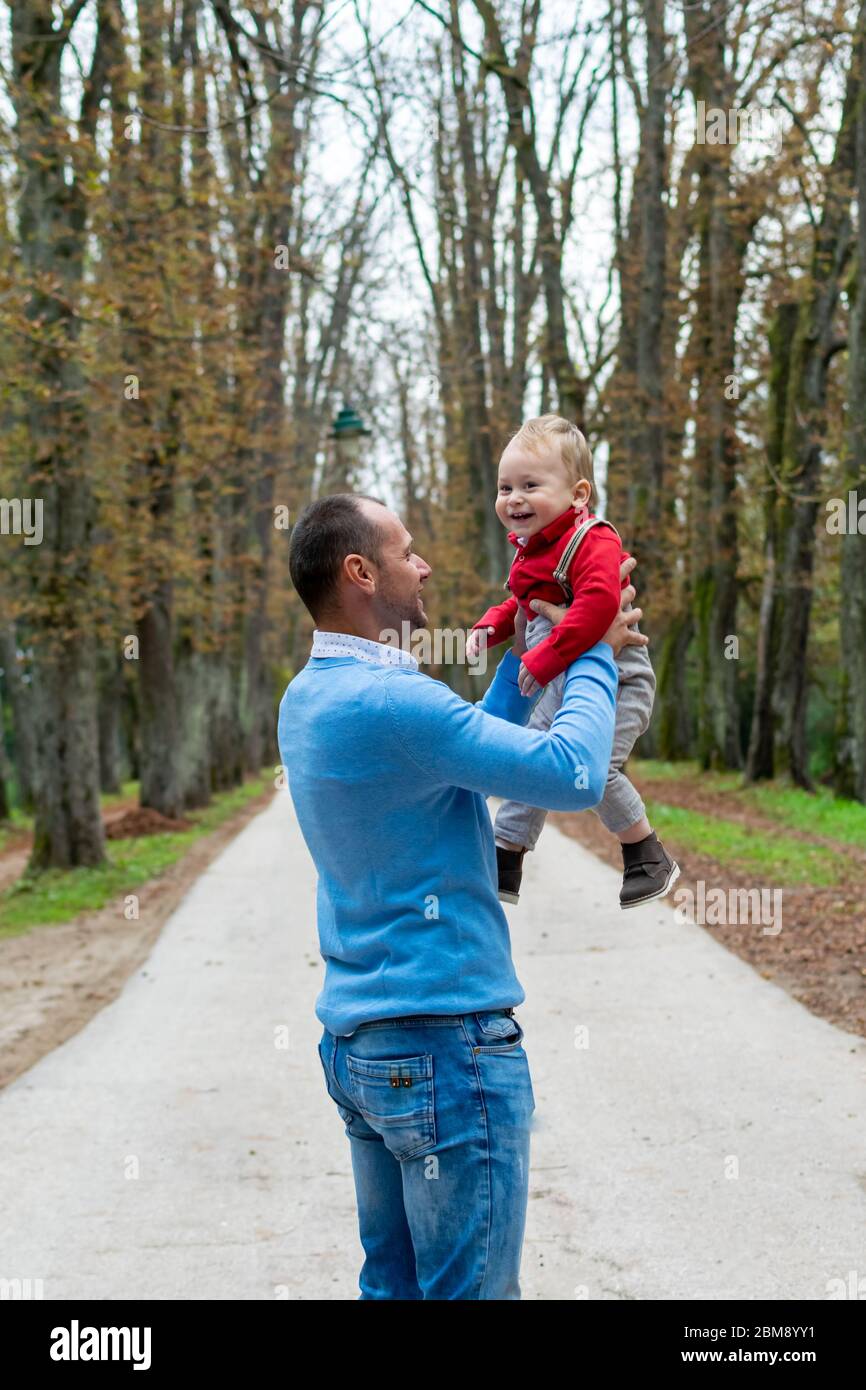 Man in 30s, father is holding his 1 year old son outdoors Stock Photo