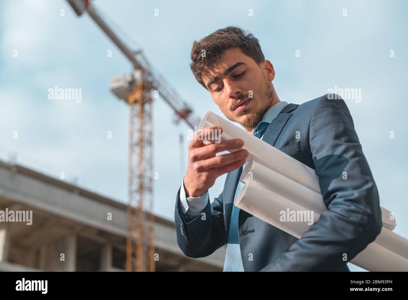Young construction engineer with yellow helmet crane and construction background , Turkey,Civil engineer ,construction Plan Stock Photo