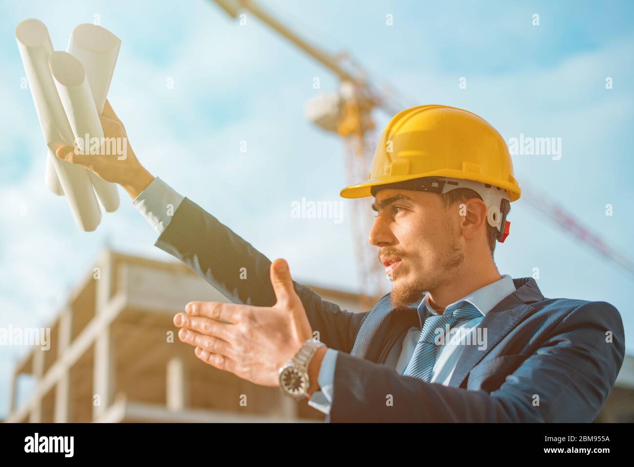 Young construction engineer with yellow helmet crane and construction background , Turkey,Civil engineer ,construction Plan Stock Photo