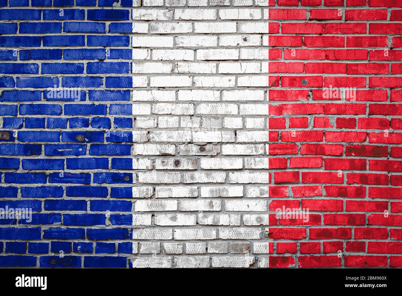 National flag of France depicting in paint colors on an old brick wall ...