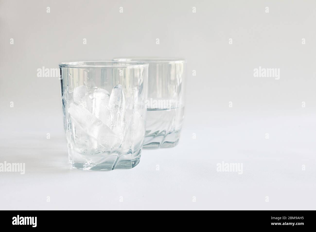Tumbler full of ice with a second glass half full of water (ice melted), Virginia, United States, color Stock Photo