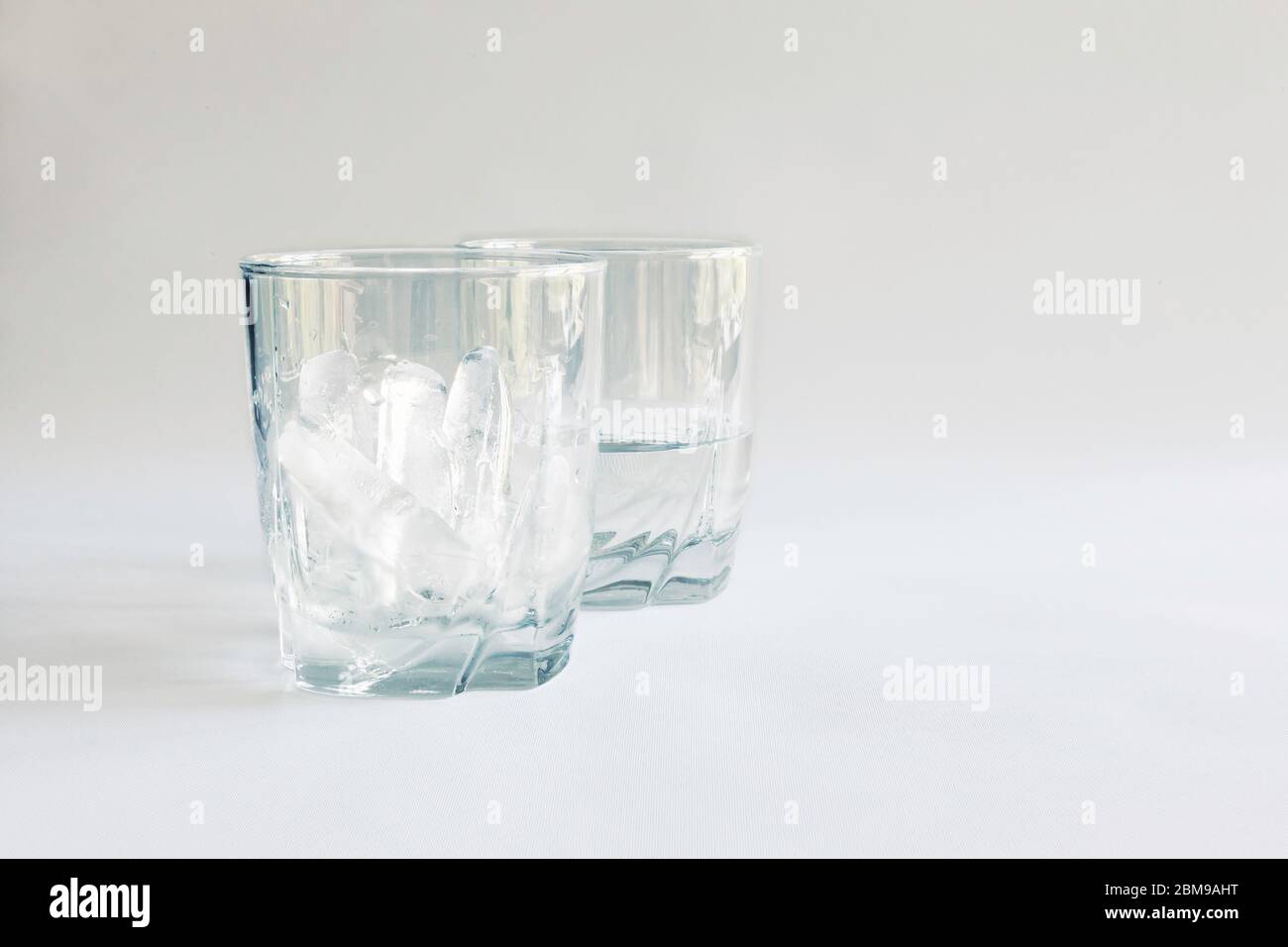 Tumbler full of ice with a second glass half full of water (ice melted), Virginia, United States, color Stock Photo